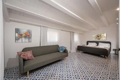 a living room with a couch and a bed at Terrazza BluOltremare, Castellammare del Golfo in Castellammare del Golfo