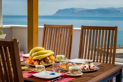 a wooden table with a plate of food on it at Terrazza BluOltremare, Castellammare del Golfo in Castellammare del Golfo