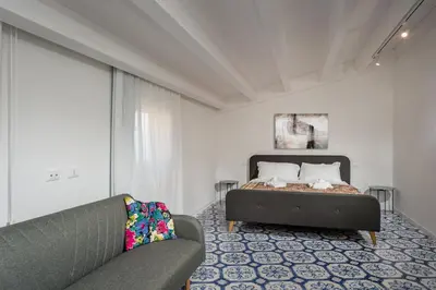 a bedroom with a bed and a couch at Terrazza BluOltremare, Castellammare del Golfo in Castellammare del Golfo