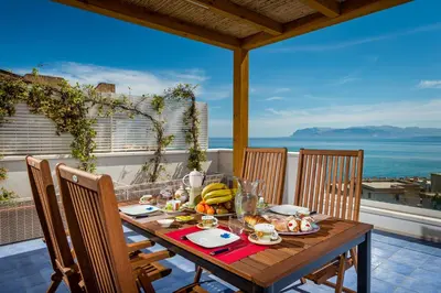 a wooden table with food on top of a balcony at Terrazza BluOltremare, Castellammare del Golfo in Castellammare del Golfo