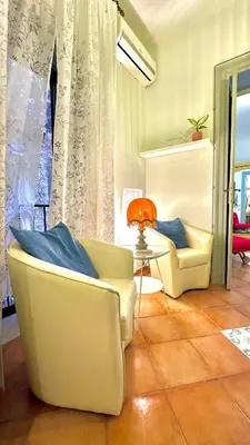 a living room with two chairs and a table at Casetta Nenè - Palermo Centrocittà - Intero Appartamento in Palermo