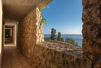 a stone wall with a view of the ocean at Seaside Villa Capo Zafferano in Bagheria
