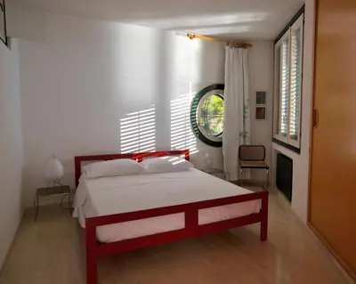 a bedroom with a red and white bed and a window at Seaside Villa Capo Zafferano in Bagheria