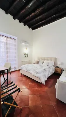 a bedroom with a large bed and a table at Kasa Magnisi in Palermo