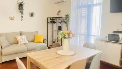 a living room with a table with a vase of flowers on it at Kasa Magnisi in Palermo