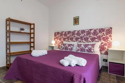 a bedroom with a purple bed with towels on it at GuestHost - Palermo Flat with Terrace near Villa Malfitano in Palermo