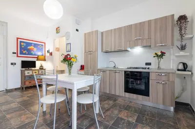 a kitchen with a white table and chairs in a room at GuestHost - Palermo Flat with Terrace near Villa Malfitano in Palermo