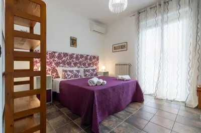a bedroom with a bed with purple sheets and pillows at GuestHost - Palermo Flat with Terrace near Villa Malfitano in Palermo