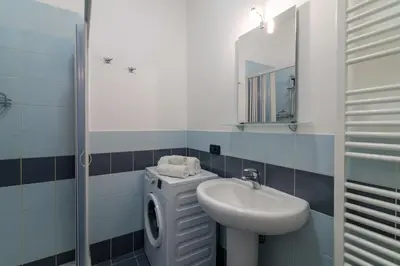 a bathroom with a sink and a washing machine at GuestHost - Palermo Flat with Terrace near Villa Malfitano in Palermo