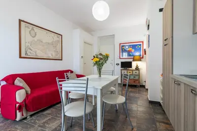 a living room with a red couch and a table with chairs at GuestHost - Palermo Flat with Terrace near Villa Malfitano in Palermo