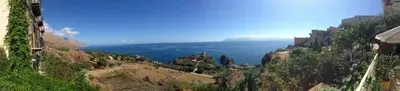 a view of a mountain with the ocean in the background at B&B Talìa in Scopello