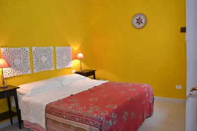 a bedroom with a bed and a clock on the wall at B&B Talìa in Scopello
