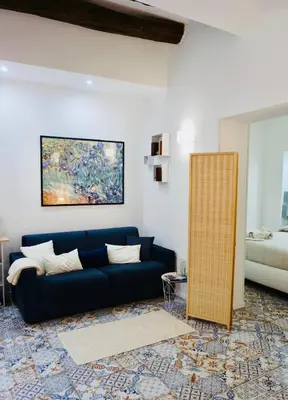 a living room with a blue couch and a painting at Elvira Studio Flat,Via Dante,near Lolli station in Palermo
