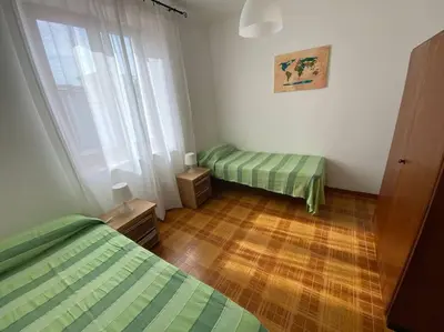 a bedroom with two beds and a wooden floor at I Cinque Archi Apartment in Alcamo