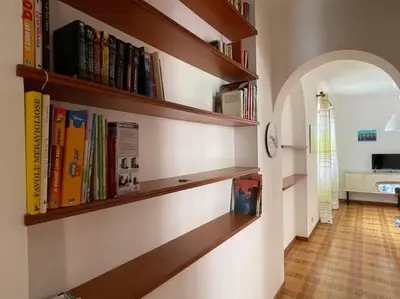 a hallway with wooden shelves with books at I Cinque Archi Apartment in Alcamo
