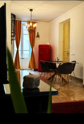a living room with a table and chairs and a red refrigerator at Luxury Apartment Palazzo Vannucci in Palermo