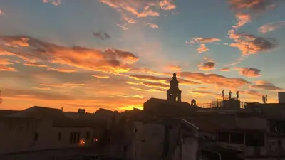 a sunset over a city with a clock tower at Note di Palermo Loft in Palermo