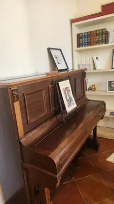 a wooden piano in a room with a book shelf at Note di Palermo Loft in Palermo