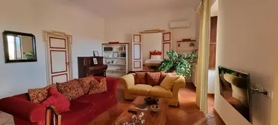 a living room with a red couch and a chair at Note di Palermo Loft in Palermo