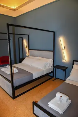 a bedroom with a bed and a table with towels at Mamamia #Teatro Biondo in Palermo