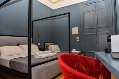a bedroom with a bed and a red chair at Mamamia #Teatro Biondo in Palermo