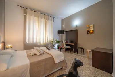 a hotel room with a bed and a desk and a room at La zagara di Alba in Palermo