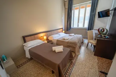 a hotel room with two beds and a table at La zagara di Alba in Palermo