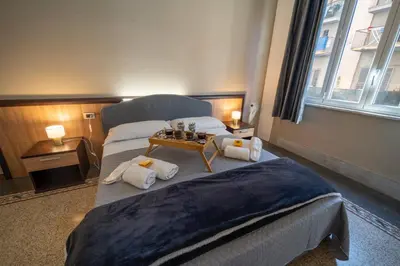 a bedroom with two beds and a table with towels at La zagara di Alba in Palermo