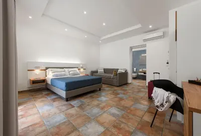 a bedroom with a bed and a couch at Le Margherite in San Vito lo Capo