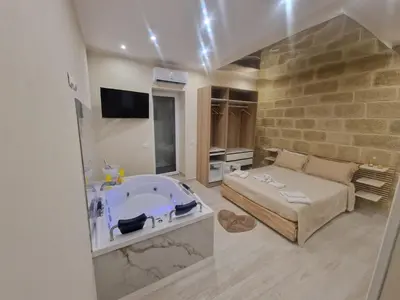 a large bathroom with a tub and a bed at Love is in the air in Palermo