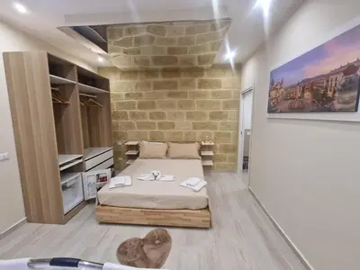 a bedroom with a bed and a stone wall at Love is in the air in Palermo