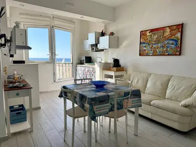 a living room with a table and a couch at Sea Pearl House in Isola delle Femmine