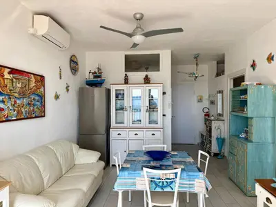 a living room with a white couch and a table at Sea Pearl House in Isola delle Femmine
