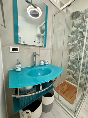 a bathroom with a blue sink and a shower at Sea Pearl House in Isola delle Femmine