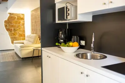 a kitchen with a sink and a bowl of fruit on a counter at Casa delle Maioliche in Palermo