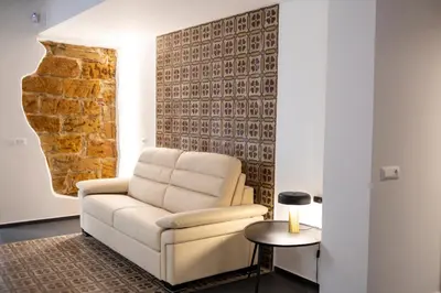 a living room with a white chair and a table at Casa delle Maioliche in Palermo