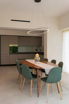 a dining room with a wooden table and green chairs at Villa Dafni Private Pool & Relax near Cefalù in Campofelice di Roccella