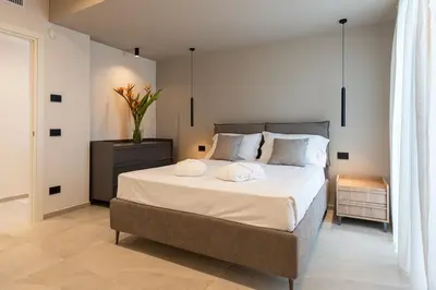 a bedroom with a large bed with white sheets and pillows at Villa Dafni Private Pool & Relax near Cefalù in Campofelice di Roccella