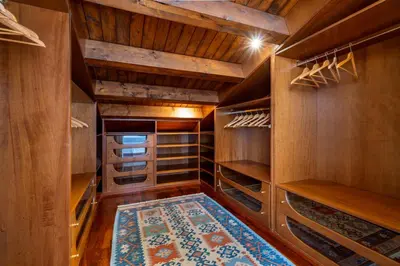 a walk in closet with wooden cabinets and a rug at Villa Bouganville in Monreale
