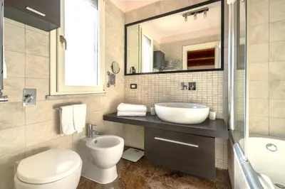 a bathroom with a sink toilet and a mirror at Villa Bouganville in Monreale
