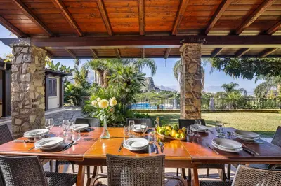 a wooden table with wine glasses on a patio at Villa Zagara Swimming Pool and Seaview in Ficarazzi