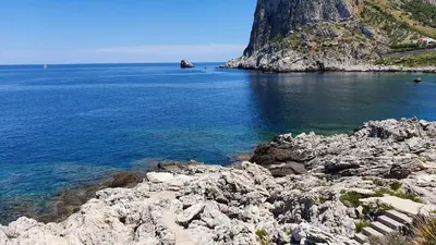 a large body of water with a rocky shore at villa Capo Zafferano in Bagheria