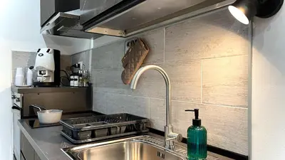 a kitchen sink with a green bottle on the counter at SILVIO'S Apartment in Castellammare del Golfo