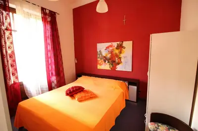 a red bedroom with a bed with orange sheets at Bovio guest House in Castellammare del Golfo