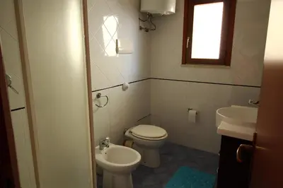 a bathroom with a toilet and a sink at Bovio guest House in Castellammare del Golfo