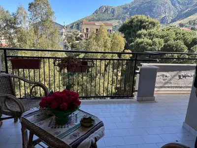 a table with a vase of flowers on a balcony at Appartamento Vista Golfo in Castellammare del Golfo