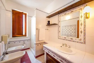 a bathroom with a sink and a toilet and a mirror at Appartamento vista mare in Castellammare del Golfo