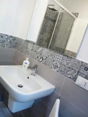 a bathroom with a white sink and a mirror at Dai Mori in Lascari
