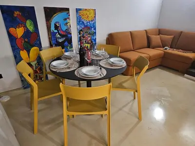 a dining room with a table and chairs and a couch at Casale Morillo in Campofelice di Roccella