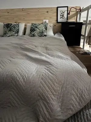 a large bed with a white comforter and pillows at Casteldaccia Stay, mieszkanko Kingi in Casteldaccia